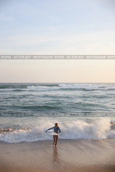 A person joyfully enjoying the waves at a beautiful sunset beach in the evening. Стоковое фото, фотограф Женя Канашкин / Фотобанк Лори