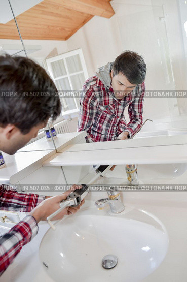 a plumber fixing a tap. Стоковое фото, агентство Ingram Publishing / Фотобанк Лори