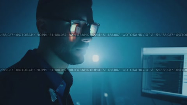 A programmer focuses intently on coding late at night in a dark room illuminated by computer screens, highlighting a dedicated workflow. Стоковое AI-видео, аниматор Данила Большаков / Фотобанк Лори