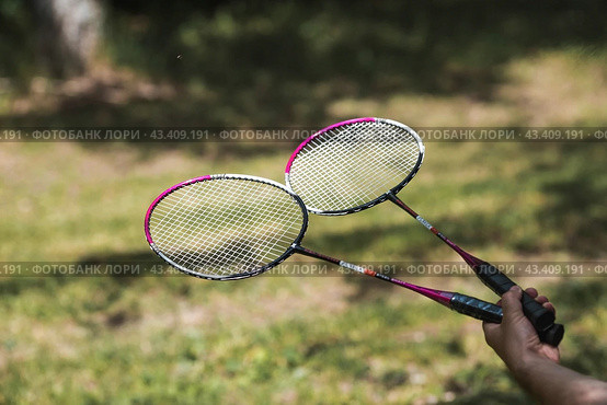 A racket and a shuttlecock on a background of green grass. Playing badminton. A summer sport. Outdoor games. Стоковое фото, фотограф Photojuli / Фотобанк Лори