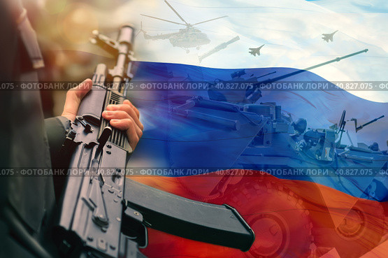 A rifle in the hands of a Russian soldier against the background of the flag of the Russian Federation and the silhouettes of military armored vehicles and aviation. The concept of mobilization. Стоковое фото, фотограф Алексей Игнатов / Фотобанк Лори