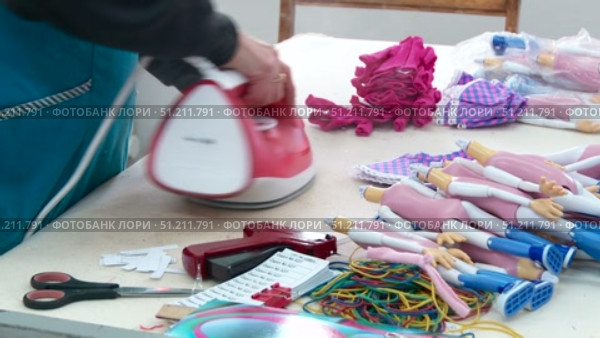 a seamstress scribbles clothes for dolls on a typewriter and smoothes it with an iron. Стоковое видео, видеограф Алексей Сергеев / Фотобанк Лори