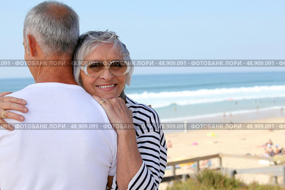 a senior woman hugging her husband near the sea. Стоковое фото, агентство Ingram Publishing / Фотобанк Лори