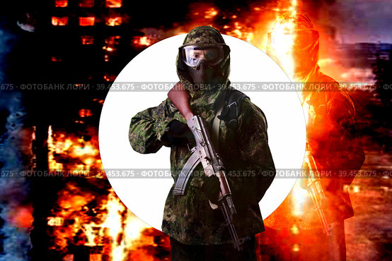 A soldier in camouflage uniform with a rifle against the background of a burning house, looks into the camera. The concept of war or the game of airsoft. Стоковое фото, фотограф Владимир Арсентьев / Фотобанк Лори