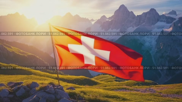 A Swiss flag waves proudly in the foreground, set against a backdrop of majestic mountains and lush green hills, symbolizing Swiss National Day. Стоковое AI-видео, аниматор Nart / Фотобанк Лори