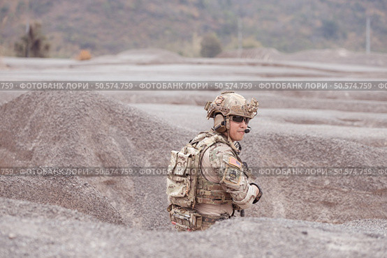 A Taliban soldier stands with a machine gun, Surrender to the allied soldiers, In the desert mountain terrain battlefield. Стоковое фото, агентство Ingram Publishing / Фотобанк Лори