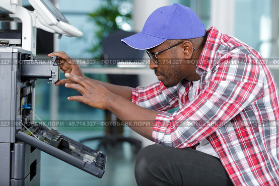 a technician is checking a printer. Стоковое фото, агентство Ingram Publishing / Фотобанк Лори