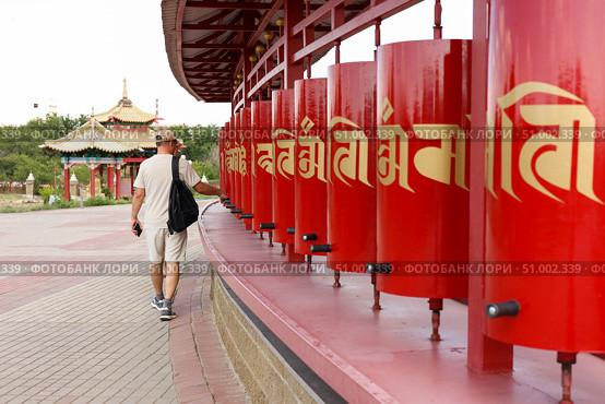 A tourist turns prayer drums of khurul, Buddhist temple Golden Abode of Buddha Shakyamuni, largest Buddhist temple in Europe, Elista, Kalmykia, Russia, July, 4, 2025. Редакционное фото, фотограф Екатерина Топорова / Фотобанк Лори