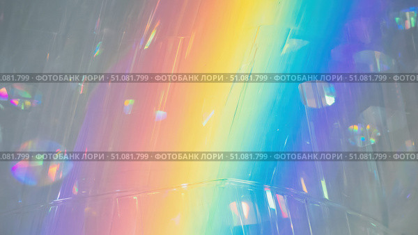 A vibrant rainbow spectrum created by light refraction through a prism. The scene features soft, blurred colors and circular light reflections. Стоковое AI-изображение, AI-художник Nart / Фотобанк Лори