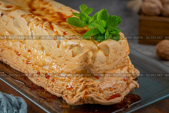 A whole molotof, a traditional caramelized egg white pudding, generously drizzled with sweet syrup and garnished with fresh mint leaves, is presented on a clear glass plate. Стоковое фото, агентство Ingram Publishing / Фотобанк Лори