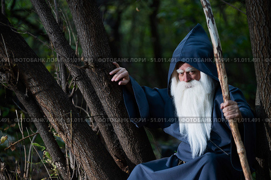 A wizard with a long gray beard and a cloak in a deep forest. An elderly man in a witcher costume. Стоковое фото, фотограф Михаил Решетников / Фотобанк Лори