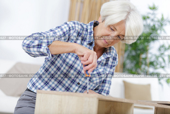 a woman fixing a furniture. Стоковое фото, агентство Ingram Publishing / Фотобанк Лори