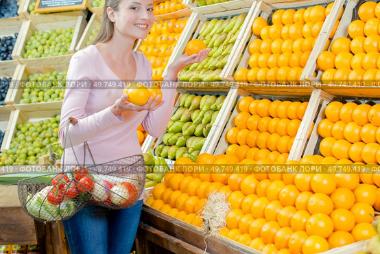 a woman is choosing oranges. Стоковое фото, агентство Ingram Publishing / Фотобанк Лори