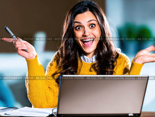 A woman is sitting at a desk with a laptop open and a pen in her hand. Стоковое AI-изображение, AI-художник Ярославский Максим / Фотобанк Лори