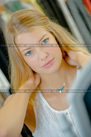 a woman is trying on necklace. Стоковое фото, агентство Ingram Publishing / Фотобанк Лори