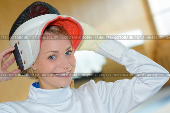 a woman putting the fencing helmet. Стоковое фото, агентство Ingram Publishing / Фотобанк Лори