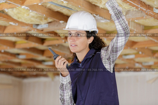 a woman uses a walkie inside construction. Стоковое фото, агентство Ingram Publishing / Фотобанк Лори