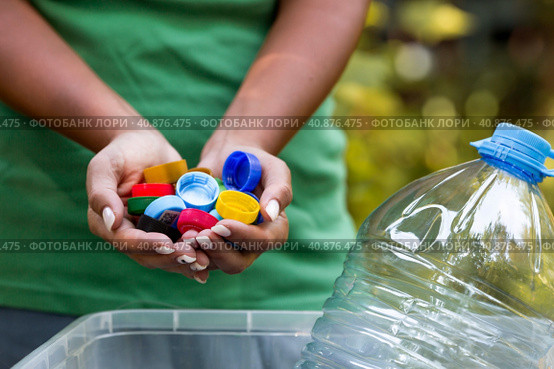 A woman's hands hold the lids of plastic bottles for recycling and environmental conservation, reuse, garbage disposal. Clean the planet of plastic garbage. Стоковое фото, фотограф Photojuli / Фотобанк Лори