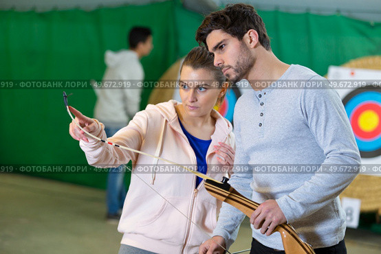 a young archer checking bow. Стоковое фото, агентство Ingram Publishing / Фотобанк Лори