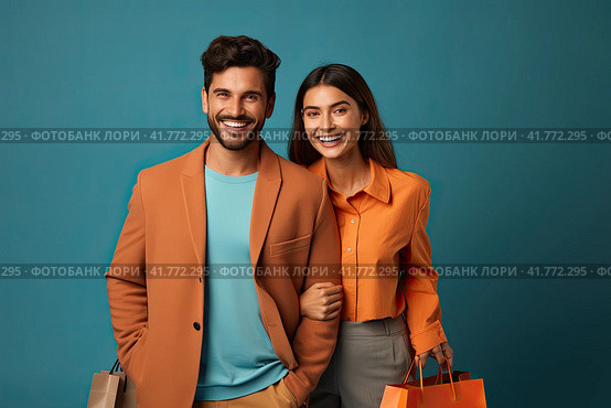 A young couple is standing with shopping bags on a blue background and smiling happily. Generated by AI. Стоковое AI-изображение, AI-художник Ярославский Максим / Фотобанк Лори