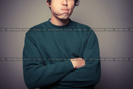 A young man is gesturing and pulling silly faces. Стоковое фото, агентство Ingram Publishing / Фотобанк Лори