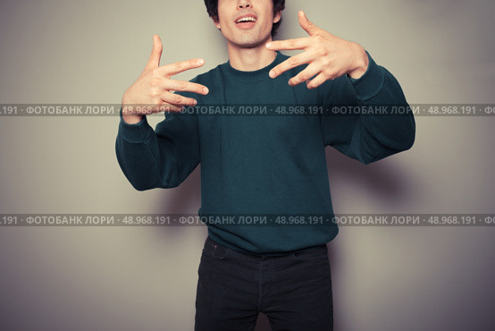 A Young man thinks he is cool and is making urban gestures with his hands. Стоковое фото, агентство Ingram Publishing / Фотобанк Лори