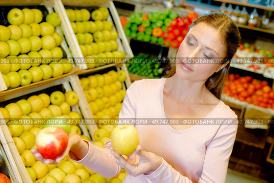 a young woman contemplating apples. Стоковое фото, агентство Ingram Publishing / Фотобанк Лори