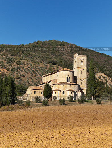 Аббатство Сант-Антимо на фоне зеленых Тосканских холмов (Abbazia di sant'Antimo, Toscana), Италия (2013 год). Стоковое фото, фотограф Виктория Катьянова / Фотобанк Лори