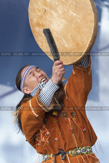 Aboriginal dancer in traditional clothes of native people dancing with tambourine. Concert Koryak Dance Ensemble Mengo (2019 год). Редакционное фото, фотограф А. А. Пирагис / Фотобанк Лори