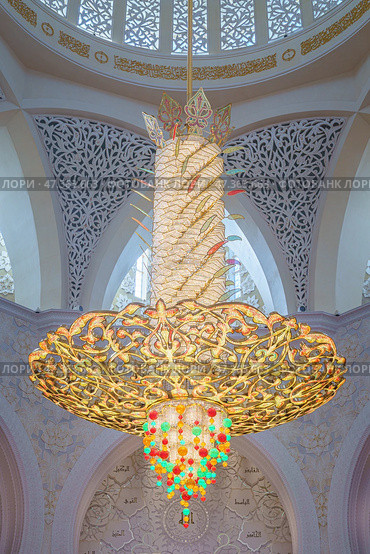 Abu Dhabi, United Arab Emirates - Jan 10 2024, View of the giant chandelier inlaid with Swarovski crystals on the ceiling of the Grand Mosque of Sheikh Zayed, Abu Dhabi, United Arab Emirates. Редакционное фото, фотограф Сергей Богомяко / Фотобанк Лори