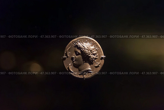 Abu Dhabi, United Arab Emirates - Jan 17 2024, Close-up view of the ancient antique coins in the Louvre Abu Dhabi Museum, belonging to different eras, Abu Dhabi, United Arab Emirates. Редакционное фото, фотограф Сергей Богомяко / Фотобанк Лори