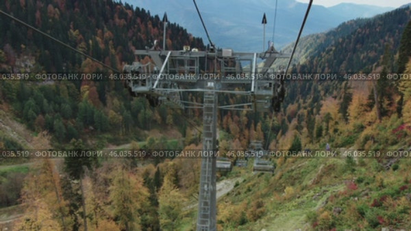 Active recreation in the mountains during autumn. Taking a scenic panoramic view from a ski lift. Активный отдых в горах осенью. Съёмка живописной панорамы с горнолыжного подъёмника. Редакционное видео, видеограф Валерий Тесаков / Фотобанк Лори