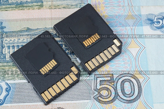 Адаптер для карты памяти Micro SD лежит на денежной купюре. Стоковое фото, фотограф Сергей Овчинников / Фотобанк Лори