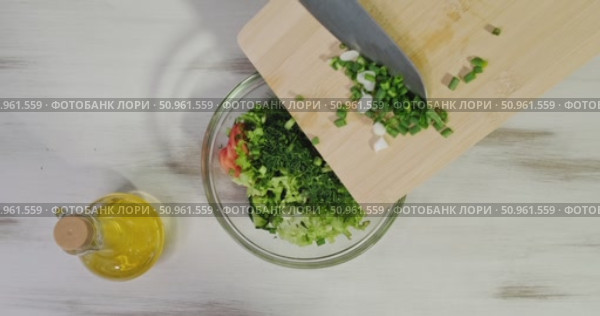 Adding Freshly Chopped Green Onion from Wooden Cutting Board into Bowl with Lettuce, Tomato, Cucumber, and Dill, Preparing Healthy Vegetable Salad for Cooking or Serving at Home. Стоковое видео, видеограф Сергей Тимофеев / Фотобанк Лори