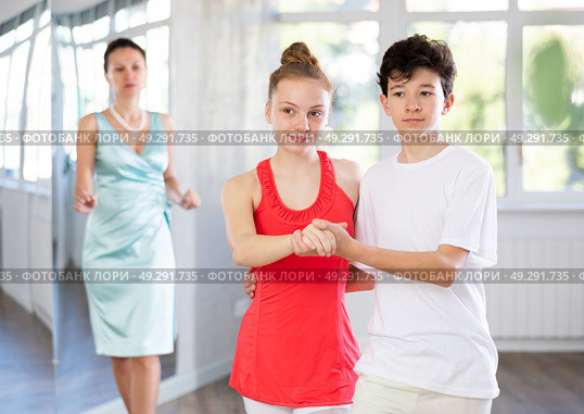 Adolescent dance duo, boy and girl, refining slow foxtrot with female coach. Стоковое фото, фотограф Яков Филимонов / Фотобанк Лори