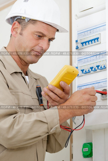 adult electrician builder working with fuseboard. Стоковое фото, агентство Ingram Publishing / Фотобанк Лори