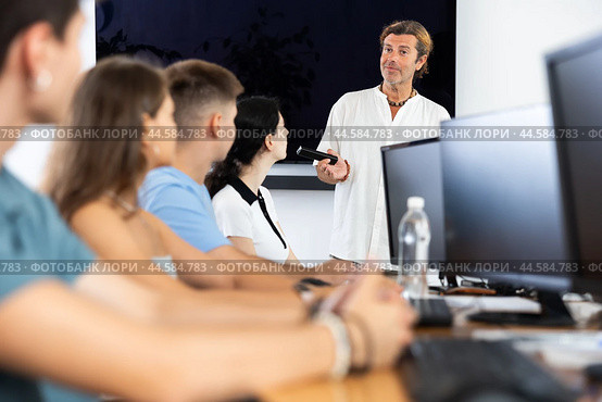Adult man speaker stands in front of students and talks about use of artificial intelligence. Стоковое фото, фотограф Яков Филимонов / Фотобанк Лори