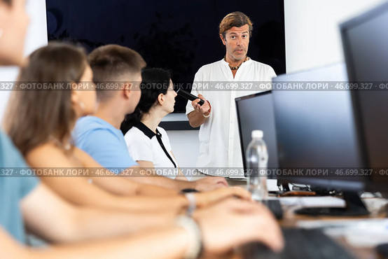 Adult man speaker stands in front of students and talks about use of artificial intelligence. Стоковое фото, фотограф Яков Филимонов / Фотобанк Лори