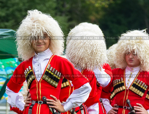 Adygea, RUSSIA - JULY 25 2015: The guys of the Adyga in beautiful red national costumes and white sheepskin hats in close-up. Редакционное фото, фотограф Андрей С / Фотобанк Лори