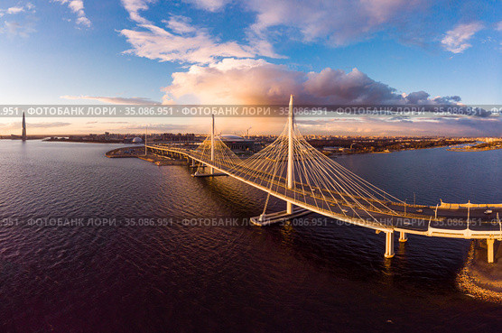 Aerial Panoramic view to evening St. Petersburg and Cable-stayed bridge across Petrovsky fairway. Western high-speed diameter WHSD at sunset. Modern highway along Neva river in a summer day. Russia. Стоковое фото, фотограф Алексей Ширманов / Фотобанк Лори
