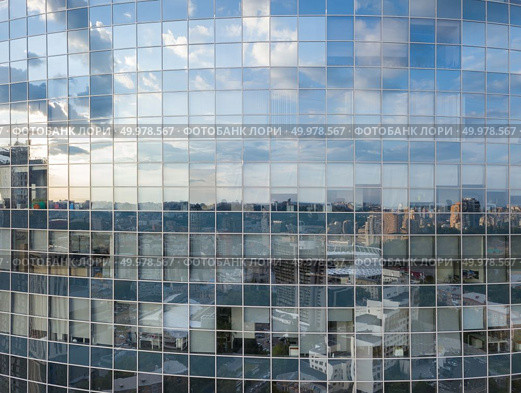 Aerial shot of modern office building windows, reflection of cityscape on a sunny day in Kiev, Ukraine.. Cityscape reflection on a glass facade of modern office building in Kiev. Стоковое фото, агентство Ingram Publishing / Фотобанк Лори