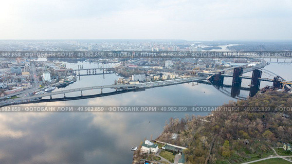 Aerial top view of Kyiv skyline, Dnieper river, Podolsky and South Bridges and Truchaniv island and Obolon district in the background from above in Kyiv Ukraine Drone photo. Aerial view of the Kiev (Kyiv) city, Ukraine. Dnieper river with bridges. Obolon district in the background. Стоковое фото, агентство Ingram Publishing / Фотобанк Лори