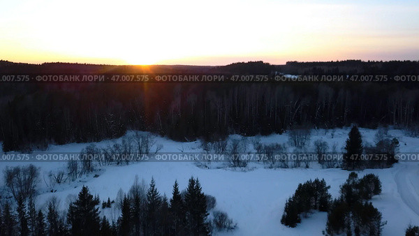 Aerial view of a snowmobile driving along pine tree forest. Стоковое фото, фотограф David Kashakhi / Фотобанк Лори