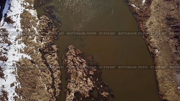 Aerial View of a Turbid River with Beautiful Snowy Banks Surrounded by Natures Landscape. Стоковое фото, фотограф David Kashakhi / Фотобанк Лори