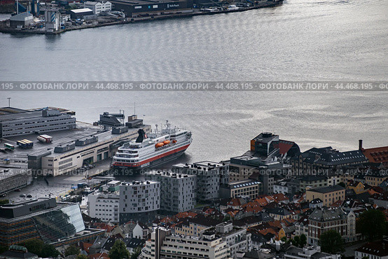 Aerial view of Bergen harbor in Norway with a docked cruise ship surrounded by modern and traditional buildings (2019 год). Редакционное фото, фотограф KOSIM / Фотобанк Лори