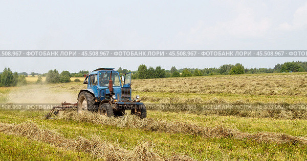 "Agricultural machinery in dusty field", "Tractor working on farmland", "Spring cultivation process", "Rural farming scene", Трактор с ворошилкой. Стоковое фото, фотограф Сергей Расторгуев / Фотобанк Лори