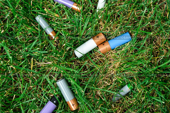 Alkaline batteries on green grass outdoors. Стоковое фото, фотограф Pixel_shot / Фотобанк Лори