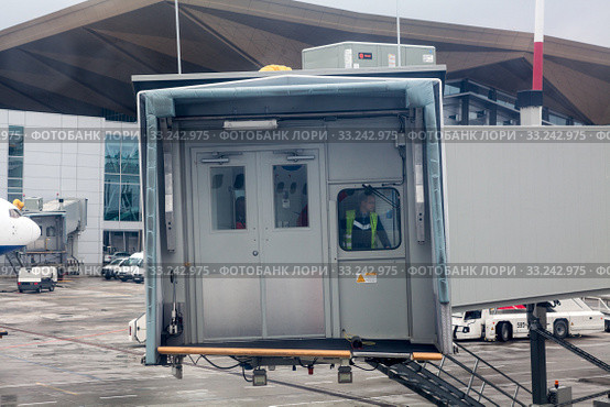All-weather dry access to aircraft with passenger boarding bridge. PBB is an enclosed, movable connector which extends from an airport terminal gate (2015 год). Редакционное фото, фотограф Кекяляйнен Андрей / Фотобанк Лори