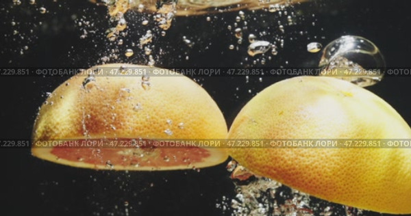 An Aesthetic Presentation of Freshly Sliced Grapefruit Against a Dark Background for Visual Appeal. Стоковое видео, видеограф Владимир Ковальчук / Фотобанк Лори