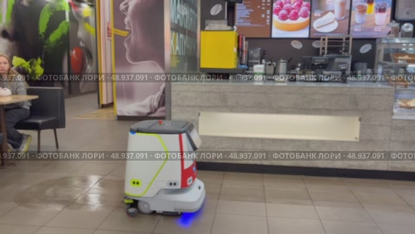 An autonomous cleaning robot moving across the shiny floor of the Vkusno i Tochka restaurant, emphasizing its modern technologies, Vkusno i tochka, Russia, Moscow, 05.05.2025. Редакционное видео, видеограф Терехова Марина / Фотобанк Лори